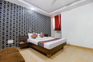 a bedroom with a bed and a couch at FabHotel Surbhi in Bhopal
