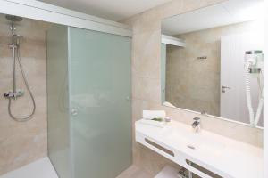 ein Bad mit einer Dusche, einem Waschbecken und einem Spiegel in der Unterkunft Typic Art in Es Cana