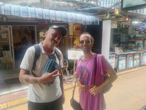 a man and a woman standing in front of a store at The City Hostel in Phi Phi Don