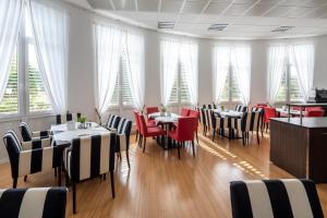 a restaurant with tables and chairs and christmas trees in the windows at Hotel Artrium am Park in Dietzenbach