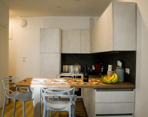 a kitchen with a counter with a table and chairs at Casaluna in Udine