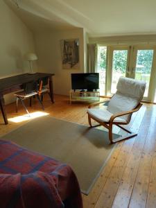 a living room with a chair and a piano at Boerderij De Diek'n in Zeerijp