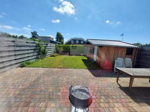 a backyard with a table and a fence at Vakantiewoning Loosdrechtse Plassen in Loosdrecht