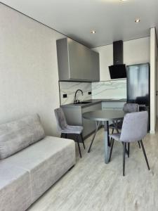 a living room with a couch and a table at Апартаменти на Марсельській 62 в ЖК Острова, 1 спальня та кухня-студія in Odesa