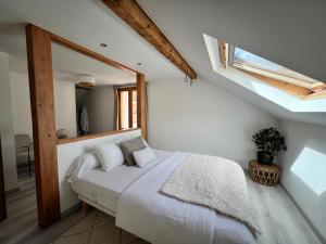 a bedroom with a white bed in a attic at Duplex MontBlanc - Suite, Centre & Parking by AlpenlySallanches in Sallanches
