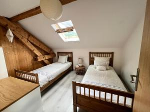 two beds in a attic room with a skylight at Duplex MontBlanc - Suite, Centre & Parking by AlpenlySallanches in Sallanches