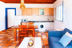 a living room with a table and a blue couch at Las dunas de Famara in Famara