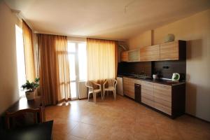 a kitchen with wooden cabinets and a table and chairs at Hotel Marant in Sozopol