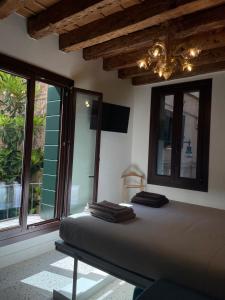 a bed in a room with windows and a chandelier at Remer Suites in Venice