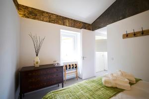 a bedroom with a bed and a dresser and a window at Sparrow Sintra Nest in Sintra