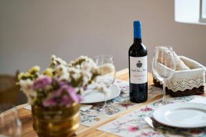 a wooden table with a bottle of wine and glasses at Sparrow Sintra Nest in Sintra