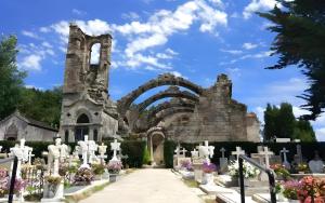 a cemetery with white gravestones and an arch at Casita Do Muelle - Cambados in Cambados