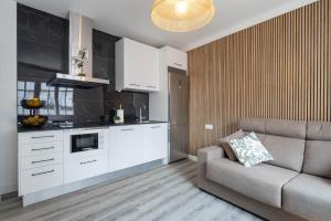 a living room with a couch and a kitchen at Casita Do Muelle - Cambados in Cambados