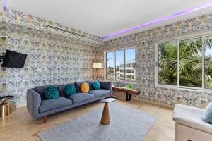 a living room with a couch and a tv at Stunning Luxury Condo Sunset 13 by Bocobay in Palm-Eagle Beach