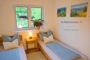 a small room with two beds and a window at Kempten mit Bauernhof-Flair in Kempten