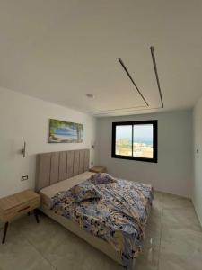 a bedroom with a bed and a window at Dar ATTIA Ezzahra KELIBIA in Ḩammām al Ghazzāz