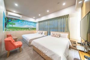 a bedroom with two beds and a tv and a chair at 羅東三好Sam-hao Homestay in Luodong +7 photos