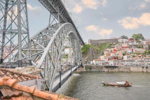 a boat on a river under a bridge at GuestReady - Douro Nest Apartments in Bandeira