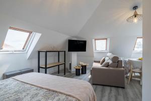 a bedroom with a bed and a couch and a tv at A Casita Do Muelle - Cambados in Cambados