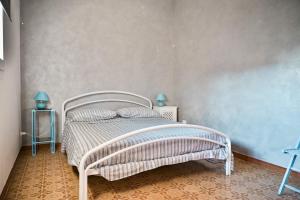 een slaapkamer met een wit bed en 2 bijzettafels bij Cosentino apartment in Marzamemi