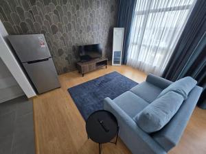 a living room with a blue couch and a television at Budget stay in Kajang town near to MRT in Kajang