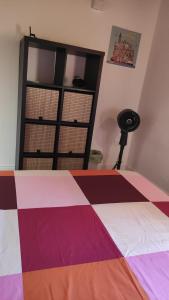 a bedroom with a bed with a colorful quilt at Arco & Íris in Livorno