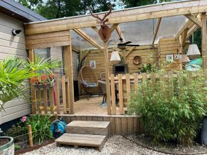 a wooden pergola with a bench and a table at Chalet Bosgeluk in Hoenderloo