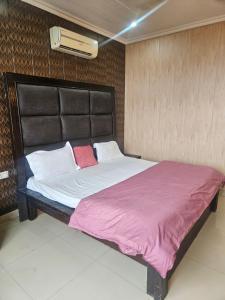 Un dormitorio con una cama grande en una habitación. en Hotel Amber Palace, en Dehradun
