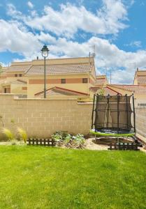 a yard with a fence and a wall with a chair at Casa VillaFlamenca in Segovia