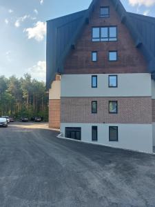 a large brick building with windows on the side of it at Apartman Šišarka Dva Divčibare in Divčibare