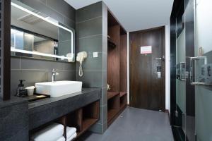 天津Nostalgia Hotel Near Tianjin Polar Ocean Word- Tianjin Fonte Joy World, 10 minutes drive away from Tianjin Tanggu High-Speed Railway Station, Free ice-cream, mineral water, snacks and laundry service, English communication well的带水槽和镜子的浴室