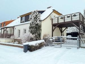 ein Haus mit einer Holzbrücke im Schnee in der Unterkunft Ferienwohnung mit großem Balkon in Bömitz in Bömitz