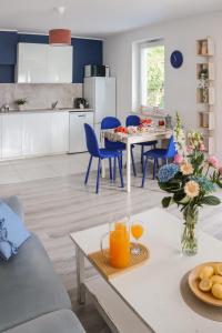 a kitchen and living room with a table and blue chairs at Keba in Władysławowo