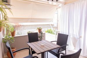 a patio with a wooden table and chairs and a window at Stonewood House in Tríkala