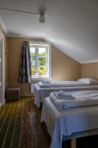 a bedroom with two beds and a window at Statsbuene i Kabelvåg in Kabelvåg