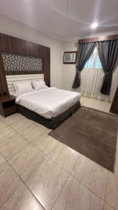 a bedroom with a large bed and a window at منازل بريدة للشقق المفروشة in Buraydah