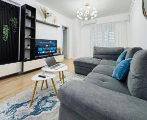 ブカレストにあるZenith Central Address Apartment with Parkingのリビングルーム(ソファ、ノートパソコン、テーブル付)