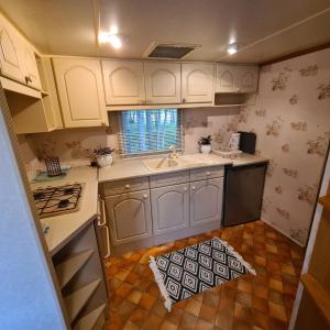 a kitchen with white cabinets and a kitchen rug on the floor at Vacation by the sea in Lapmežciems