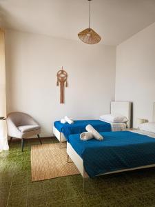a bedroom with two beds and a chair in it at Casa GIOSA in Baia Verde