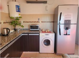 a kitchen with a refrigerator and a washing machine at Lucipri CyN in Arroyito +12 photos