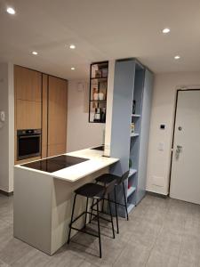 a kitchen with a white counter and stools at Casa in residence - Padenghe sul Garda in Padenghe sul Garda