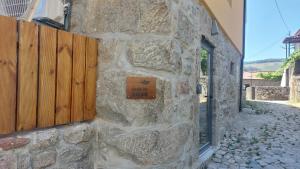 a stone wall with a sign on the side of a building at Green Paradise Glamping in Covas