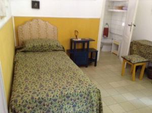 a bedroom with a bed and a table and a ladder at Villino a Fiuggi in Fiuggi