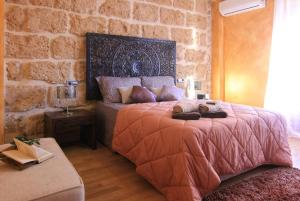 a bedroom with a bed and a stone wall at Casa Marron Boutique Home in Benissa