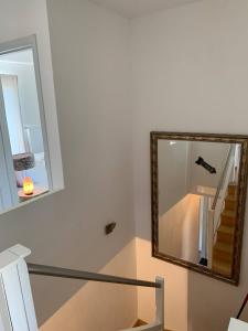 a mirror on the wall next to a staircase at Maison en bois in Lontzen