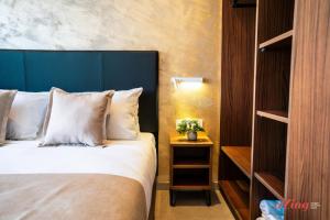 a bedroom with a bed with a blue headboard at Ta' Guzeppi Boutique Stays Near St Thomas Bay in Il-Maħsel