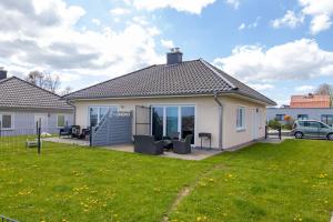 a house with a lawn in front of it at Ferienwohnungen am Hafen in Stahlbrode
