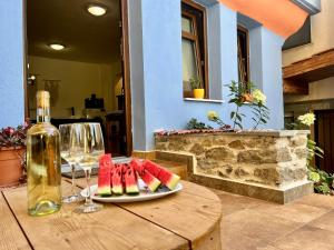 a table with a plate of watermelon and a bottle of wine at Blue City Studio in Kavála