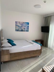 a bedroom with a large bed with blue pillows at REZEVICI BOUTIQUE VILLA in Petrovac na Moru