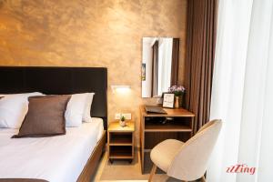 a bedroom with a bed and a desk with a mirror at Ta' Guzeppi Boutique Stays Near St Thomas Bay in Il-Maħsel